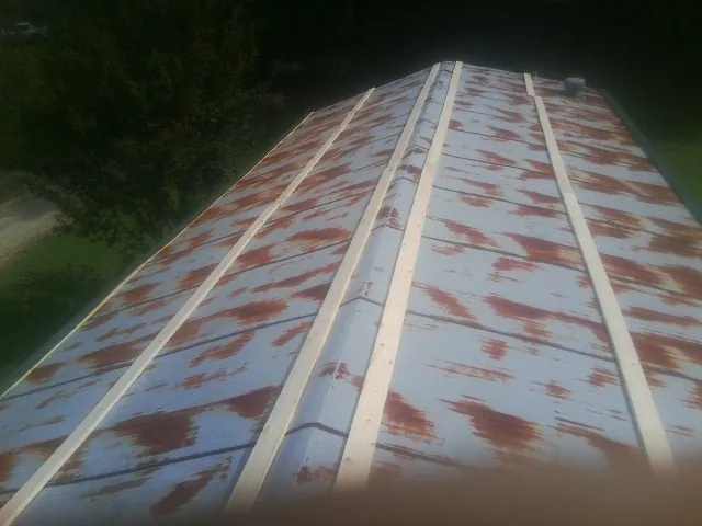 Rusted metal roof panels with new wood purlins before replacement — Storm Damage Roof Repair in Huntsburg by Roofing Brothers